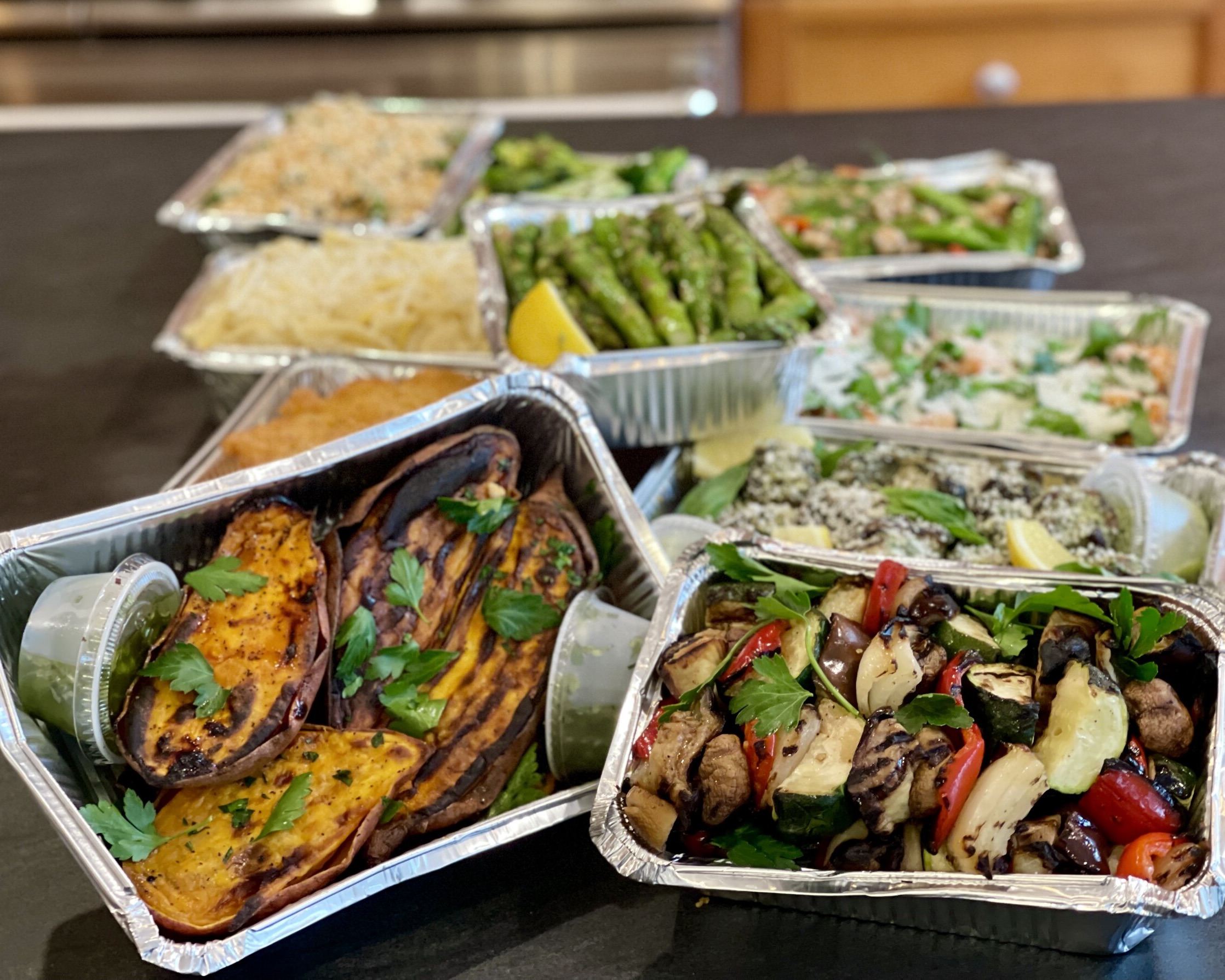 Photo of different meals in metal containers on a counter