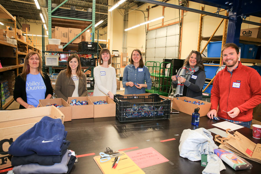 adults helping volunteer at food shelf